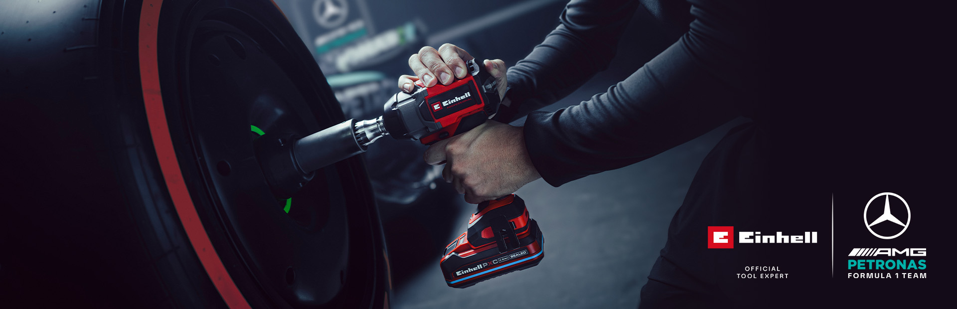 Llave de impacto inalámbrica Einhell en uso sobre una rueda de auto, con el branding y el logotipo de colaboración del equipo Mercedes-AMG Petronas de Fórmula 1