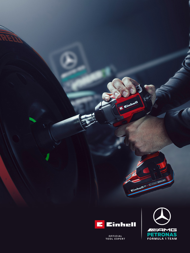Llave de impacto inalámbrica Einhell en uso sobre una rueda de auto, con el branding y el logotipo de colaboración del equipo Mercedes-AMG Petronas de Fórmula 1